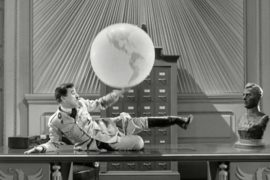 Hitler fiddling with globe, a scene from The Great Dictator