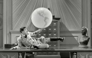 Hitler fiddling with globe, a scene from The Great Dictator