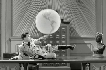 Hitler fiddling with globe, a scene from The Great Dictator