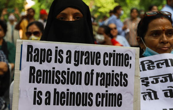 A demonstrator holds a placard during a protest against the release of the convicts in Bilkis Bano case