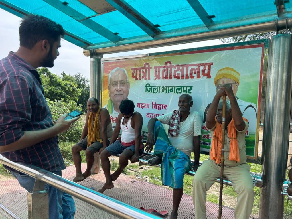 Guarav Gulmohar in conversation with waiting passengers at a bus stop in Bihar 
