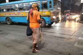 A saffron clad man crossing College Street in Kolkata