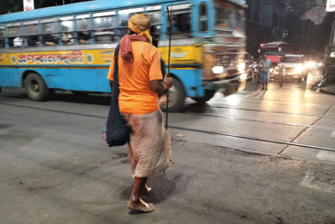 A saffron clad man crossing College Street in Kolkata
