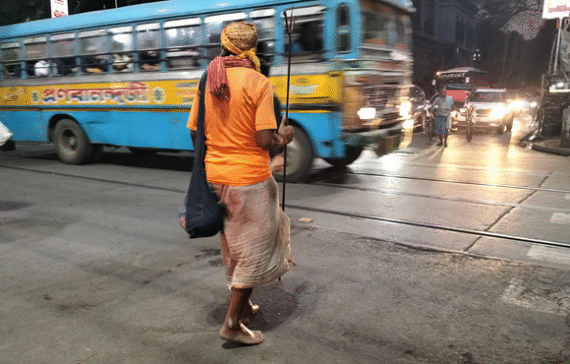A saffron clad man crossing College Street in Kolkata